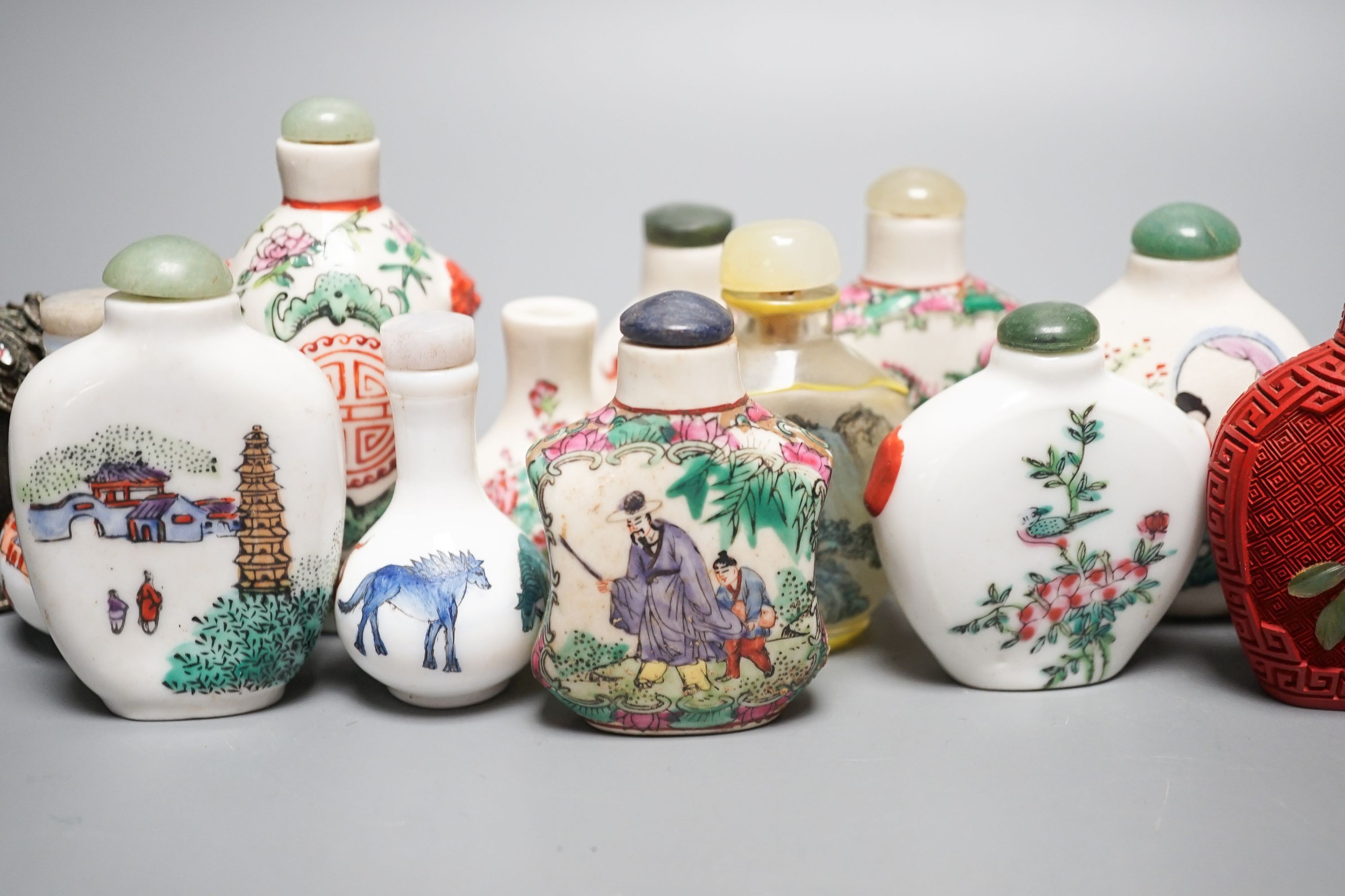 A collection of Chinese snuff bottles, 20th century, including a carved cinnabar lacquer and hardstone inlaid snuff bottle, 7.4cm (23)